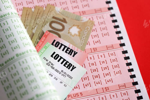 Preview: Lottery tickets lies with canadian dollars on gambling sheets with numbers
