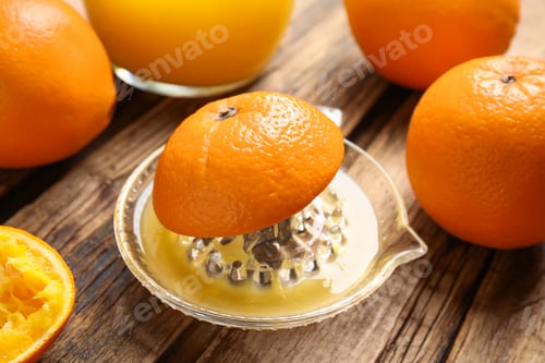 Preview: Fresh ripe oranges and squeezer on wooden table, closeup