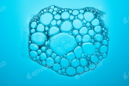 Preview: The texture of soap bubbles and foam in close-up on a blue background.