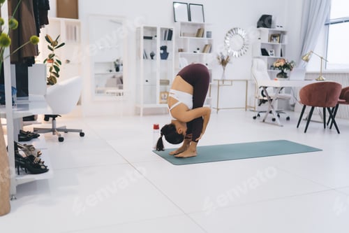 Preview: Fit woman doing standing forward bend yoga in pose