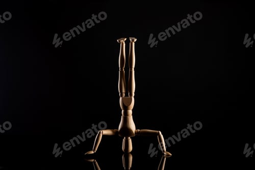 Preview: Wooden Doll in Headstand Position on Black