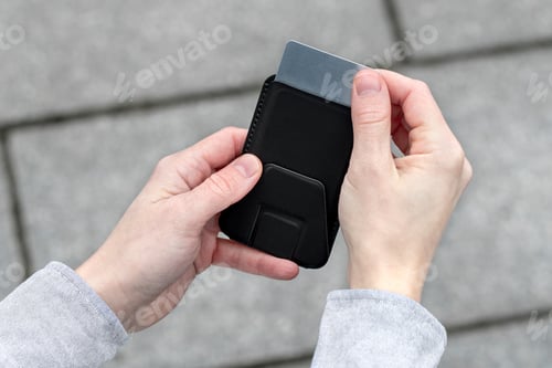 Preview: Woman pulling out credit card outside in city