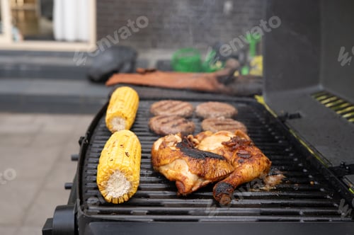Preview: Grilled chicken and corn with burgers on backyard barbecue grill