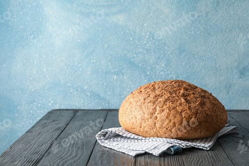 Preview: Bread on kitchen towel on wooden table against light background, space for text