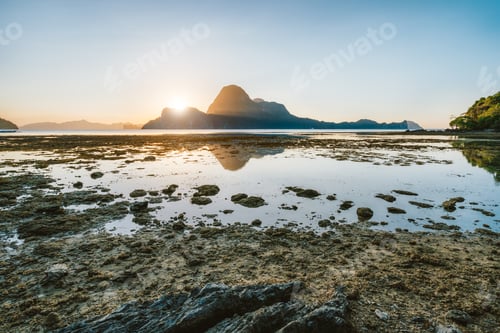 Preview: Sunset scene of El Nido shore lit by sunset light at low tide. Picturesque nature scenery. Palawan