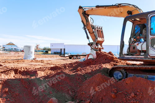 Preview: Excavator operating on construction site with fresh earth being moved in afternoon sunlight