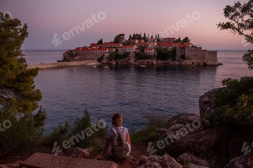 Preview: Adult pregnant woman in vest, white overalls stands by the sea. The concept of motherhood in travel