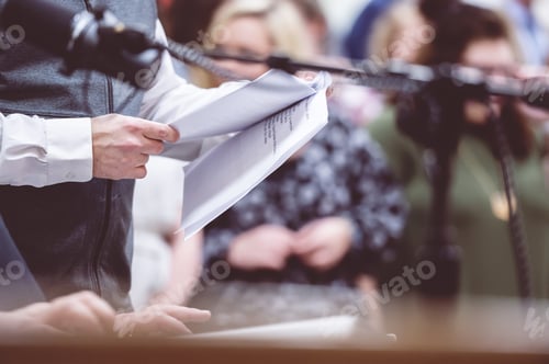 Preview: Closeup shot of a man's hand keeping a book on his hands near to the microphone