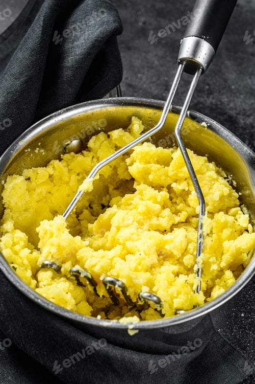 Preview: Mashed potatoes with milk and eggs in a pot. black background. top view