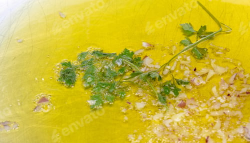 Preview: Chopped Garlic and onion frying with olive oil in a big frying pan outdoor close up