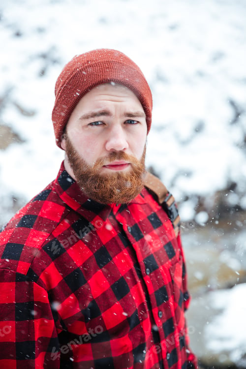 Preview: Serious handsome bearded man outdoors in snowy weather