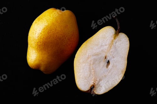 Preview: Beautiful ripe yellow pear cut in a half on black background