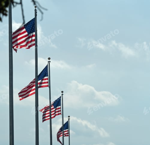 Preview: Low angle shot of the flags of the USA under a cloudy sky