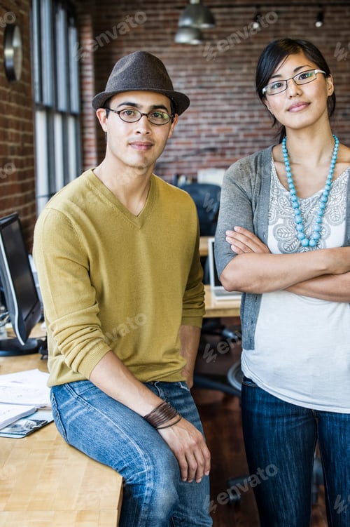 Preview: Asian woman and Hispanic man together at a creative office work station.