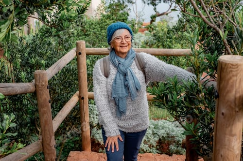 Preview: Senior caucasian woman on hiking trip with backpack enjoying freedom and nature