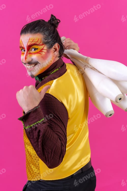 Preview: Juggler in a vest and with painted face juggling with maces on a pink background, doing ok
