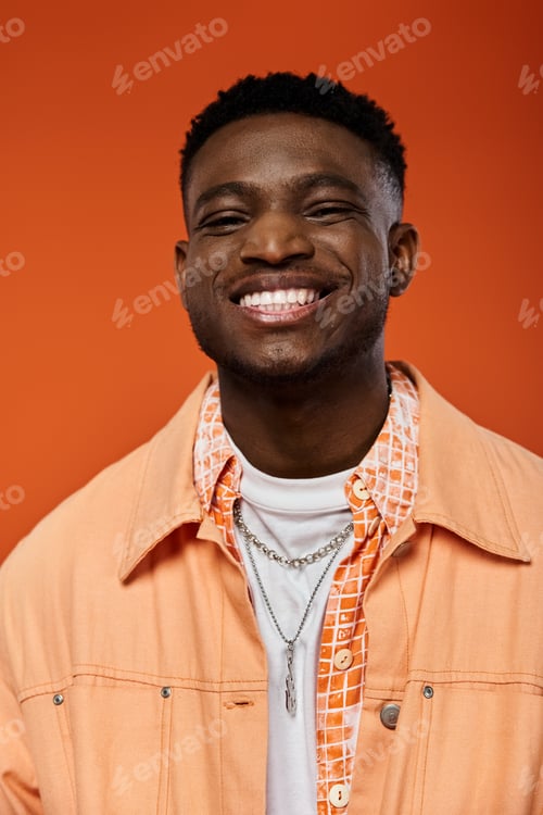 Preview: Stylish Young Man in Vibrant Orange Jacket