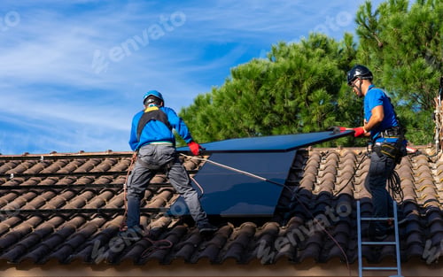 Preview: Solar panel installers working on the roof of a house