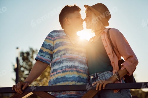 Preview: Happy lesbian couple in love touching with their noses at sunset.