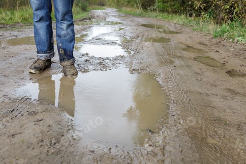 Preview: Man in dirty shoes standing in the mud