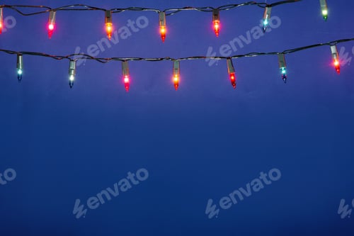 Preview: Christmas lights string on blue background with copy space