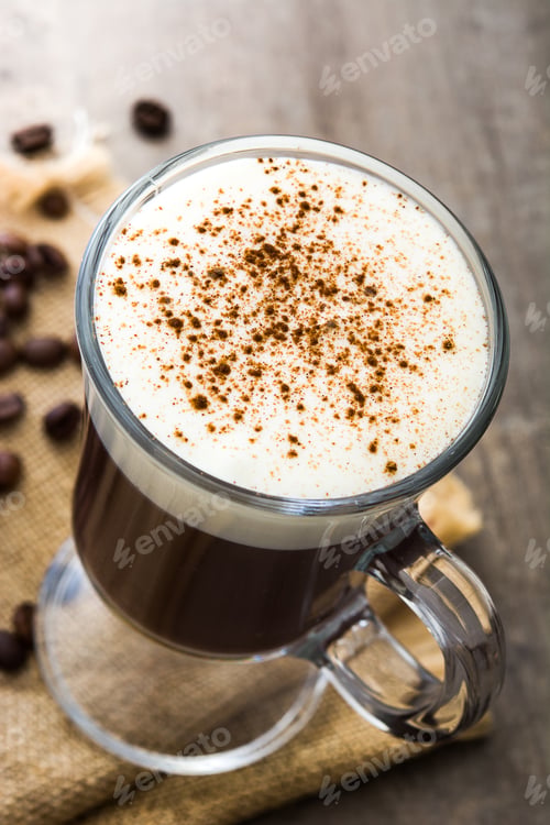 Preview: Irish coffee with whipped cream and cinnamon in a glass cup on burlap