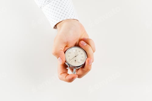 Preview: Close up of hand holding stopwatch, isolated on white background