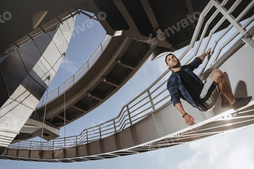 Preview: Portrait of parkour athlete climbing on the bridge.