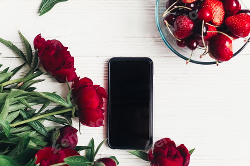 Preview: stylish phone with empty screen and beautiful red peonies