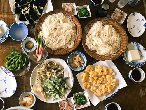 Preview: Japanese family lunch with noodles tempura and fresh vegetables.