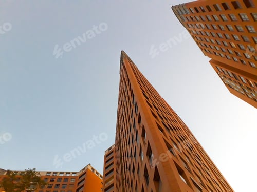 Preview: Tall, sharp homes, challenging brick buildings with blue sky.