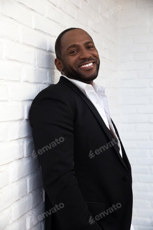Preview: Handsome cheerful african american business man in classy black suit.
