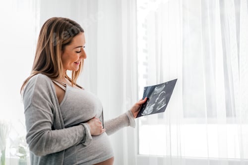Preview: Pregnant woman at home looking her baby on ultrasound image, usg photo