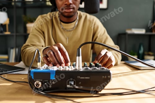 Preview: Focus on hands of young male host turning consoles of soundboard