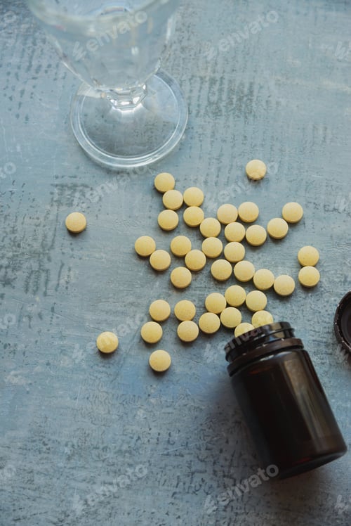 Preview: yellow round tablets or pills vitamins lay on blue table
