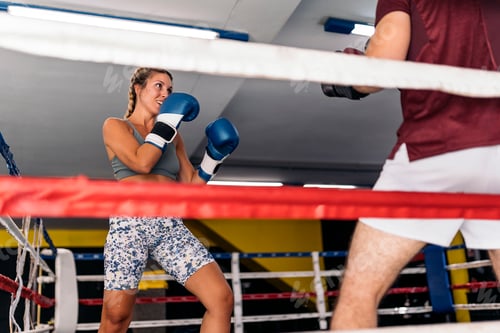 Preview: Young adult man and woman training box on the ring