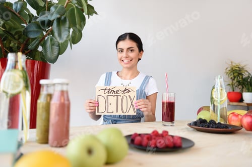 Preview: portrait of smiling woman holding time to detox card and looking at camera