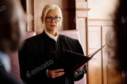 Preview: Confident mature judge announcing verdict while looking at attorney and suspect