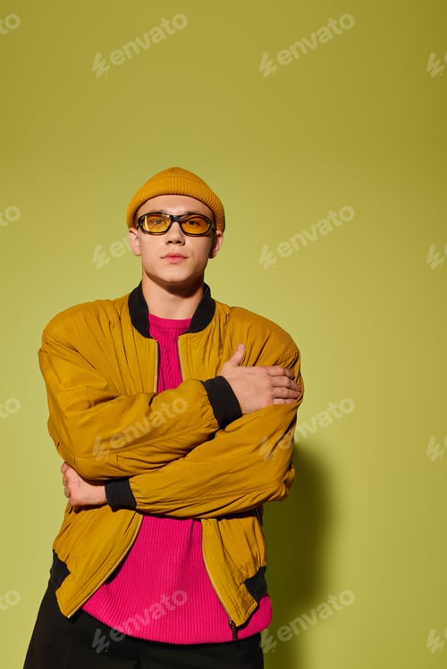 Preview: Stylish young man showcases trendy fashion in vibrant studio setting