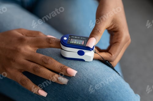 Preview: Unrecognizable African American Woman Using Oximeter At Home, Checking Oxygen Saturation