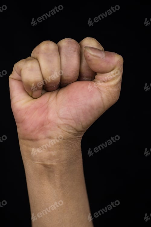 Preview: Middle-aged woman with stretched up arm showing her fist showing women empowerment and rights