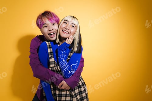 Preview: Asian couple with multicolored hair hugging and laughing together