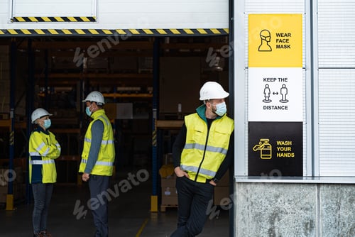 Preview: Group of workers with face mask talking in front of warehouse, coronavirus concept.
