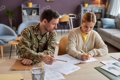 Preview: Front view father wearing military uniform helping daughter with homework