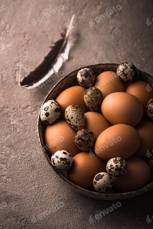 Preview: Chicken and quail eggs on brown background