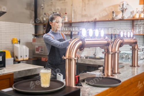 Preview: Portrait of Asian bartender girl hand at beer tap pouring , waitress or staff serve and craft