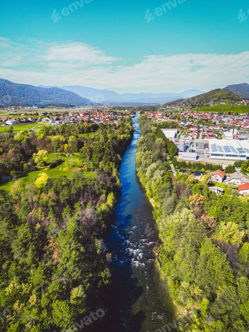 Preview: Vertical photo of a river running trough the suburbs on a sunny spring day