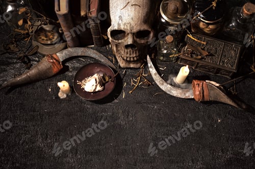 Preview: High angle view of a skull with lit candles and books on a black table - cool for backgrounds