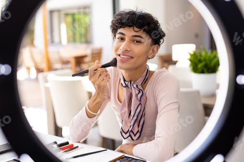 Preview: Applying makeup with brush, transgender woman smiling and looking at camera