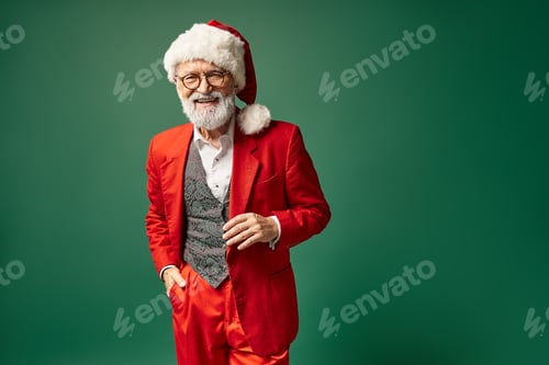 Preview: handsome elegant Santa with red christmassy hat and glasses looking at camera, winter concept